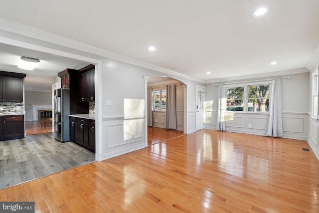 2220 Timothy Dr, Westminster, MD 21157 - unfurnished living room featuring light wood-style flooring, visible vents, crown molding, and arched walkways