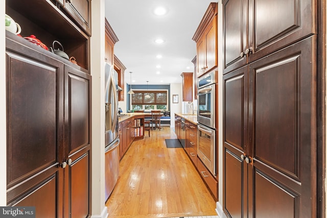 76 Deepdale Rd, Wayne, PA 19087 - kitchen with light wood-type flooring, appliances with stainless steel finishes, recessed lighting, light countertops, and hanging light fixtures