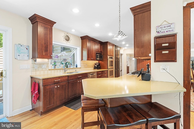 76 Deepdale Rd, Wayne, PA 19087 - kitchen featuring appliances with stainless steel finishes, tasteful backsplash, light wood-style floors, a kitchen breakfast bar, and recessed lighting