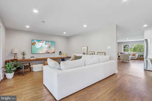 living room with recessed lighting, light wood-style flooring, and visible vents