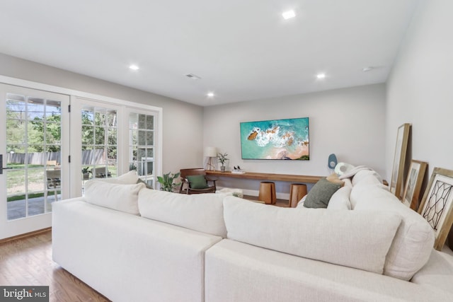 living room with recessed lighting, wood finished floors, and visible vents
