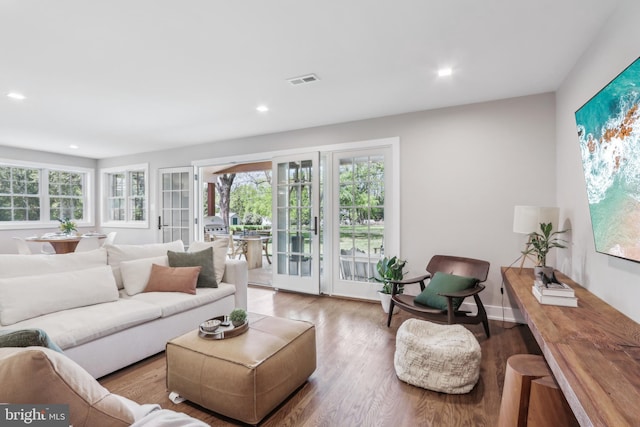 living room with a healthy amount of sunlight, recessed lighting, wood finished floors, and visible vents