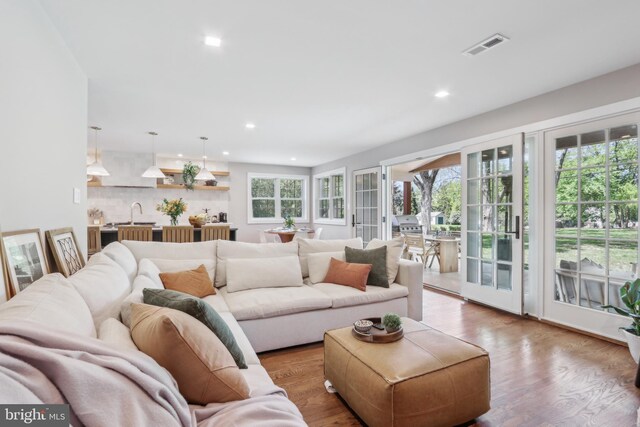 living room featuring recessed lighting, wood finished floors, and visible vents