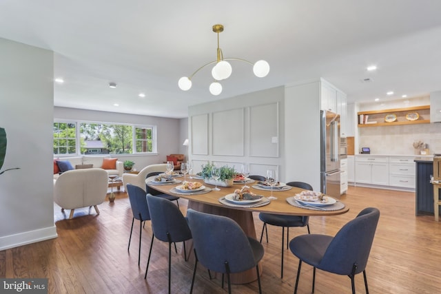 dining area featuring recessed lighting, bar area, and light wood-style floors