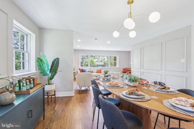 dining area featuring plenty of natural light, recessed lighting, wood finished floors, and a chandelier
