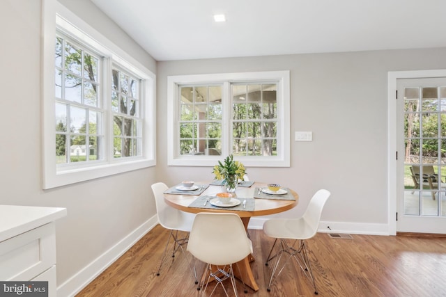 dining space featuring baseboards, visible vents, and wood finished floors