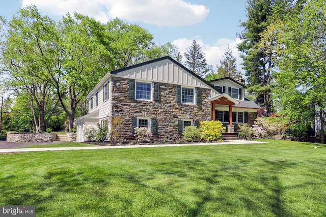 view of front of house with a chimney, board and batten siding, a front yard, and stone siding