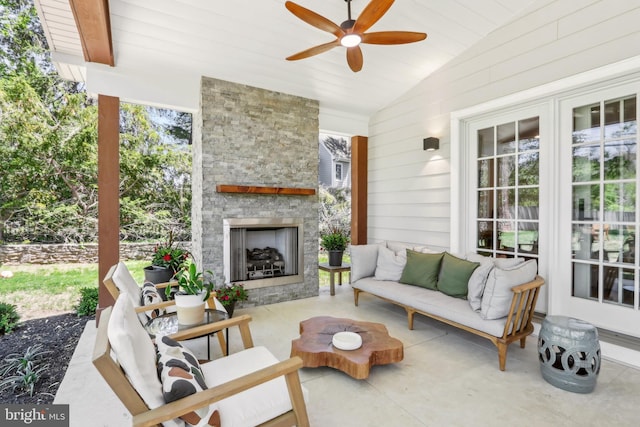 view of patio featuring a ceiling fan and an outdoor living space with a fireplace