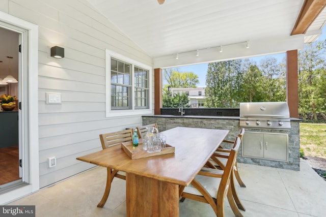 view of patio with outdoor dining space, exterior kitchen, and a grill