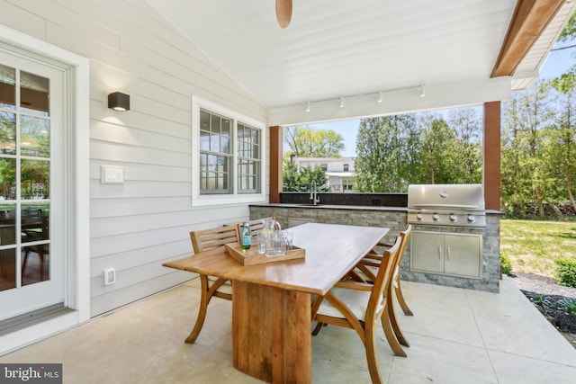 view of patio / terrace with outdoor dining space, a sink, and area for grilling