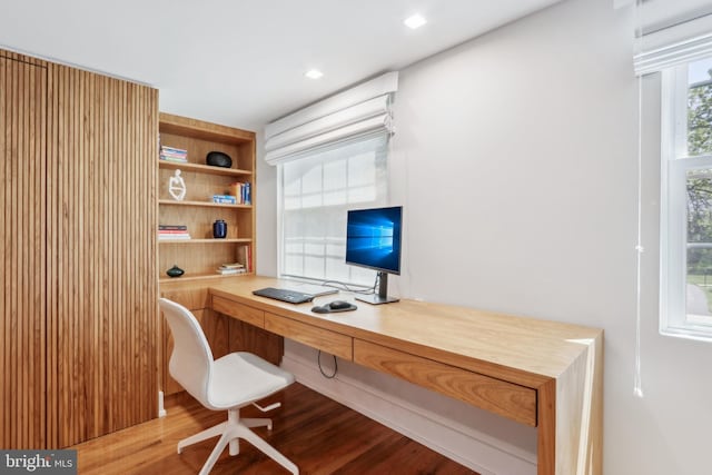 office area with built in desk and wood finished floors