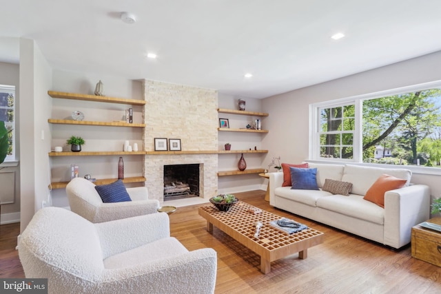 living area featuring recessed lighting, wood finished floors, and a fireplace