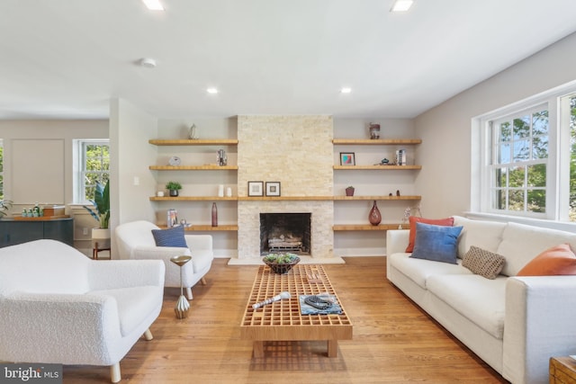 living area featuring recessed lighting, wood finished floors, and a fireplace