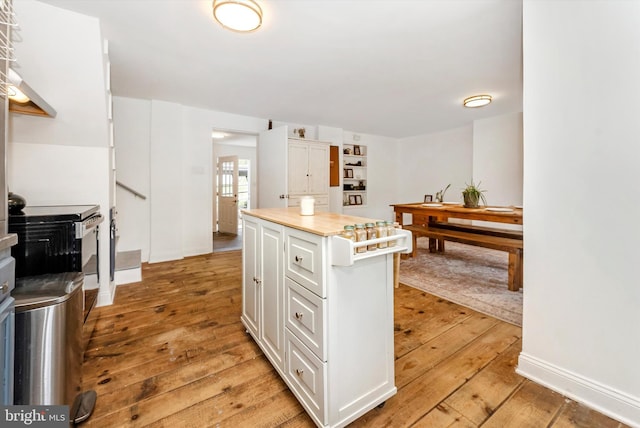 5431 Hines Rd, Frederick, MD 21704 - kitchen with a kitchen island, white cabinetry, light countertops, baseboards, and light wood-style flooring