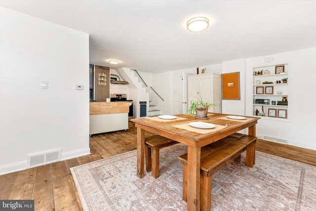 5431 Hines Rd, Frederick, MD 21704 - dining space featuring visible vents, baseboards, stairway, built in shelves, and light wood finished floors