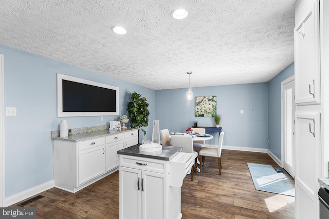 kitchen featuring white cabinets, baseboards, dark wood-style flooring, and visible vents