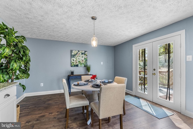 dining space with french doors, baseboards, a textured ceiling, and dark wood finished floors