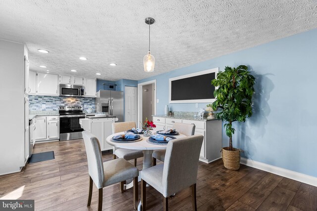 dining space with baseboards, wood finished floors, a textured ceiling, and recessed lighting