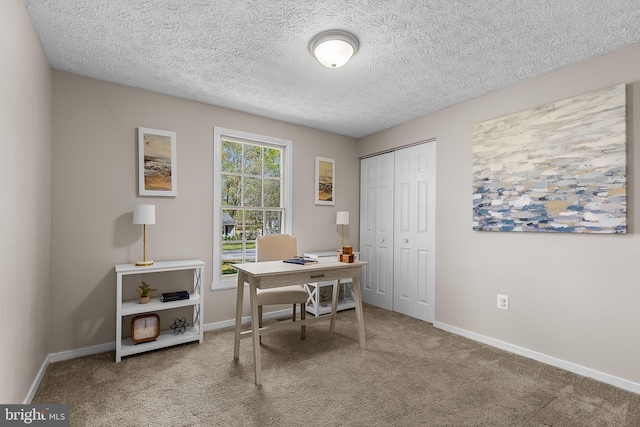 carpeted home office with baseboards and a textured ceiling