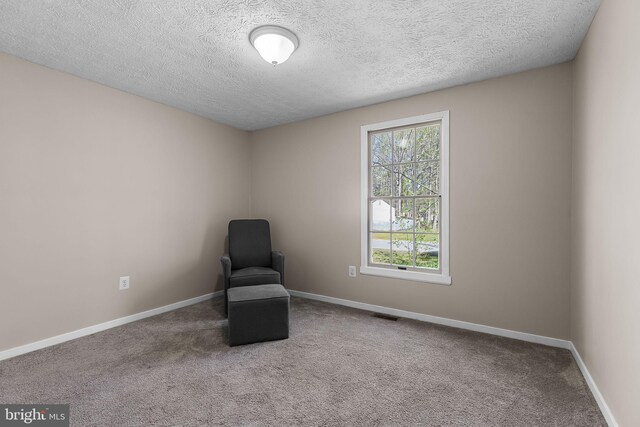 unfurnished room featuring baseboards, a textured ceiling, visible vents, and carpet