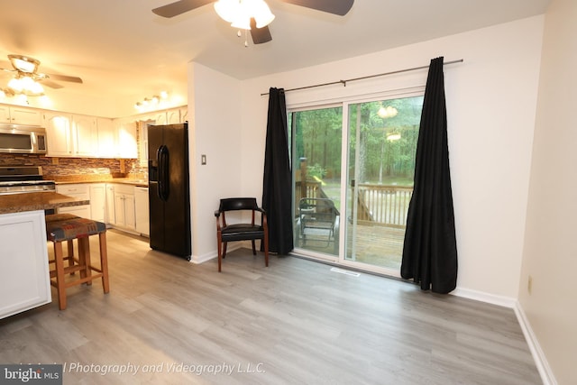 kitchen with stainless steel appliances, ceiling fan, backsplash, and light wood-style flooring