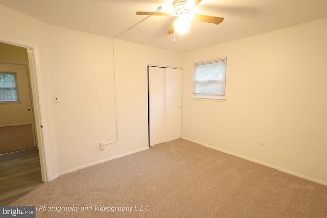 unfurnished bedroom featuring carpet, a closet, and baseboards