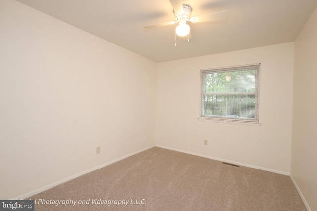 spare room with carpet, ceiling fan, and baseboards