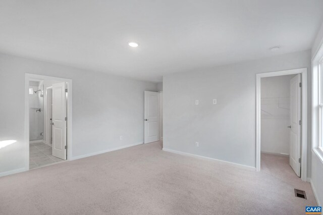 2963 Rambling Brook Ln, Crozet, VA 22932 - unfurnished bedroom with visible vents, baseboards, a closet, a walk in closet, and light carpet