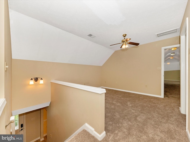 bonus room with carpet flooring, lofted ceiling, a ceiling fan, and visible vents