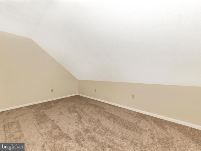 bonus room featuring carpet, baseboards, and lofted ceiling