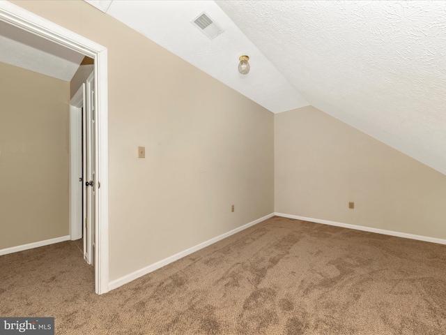 bonus room featuring carpet flooring, visible vents, baseboards, and vaulted ceiling