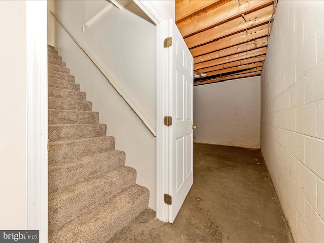 stairway with concrete floors and concrete block wall