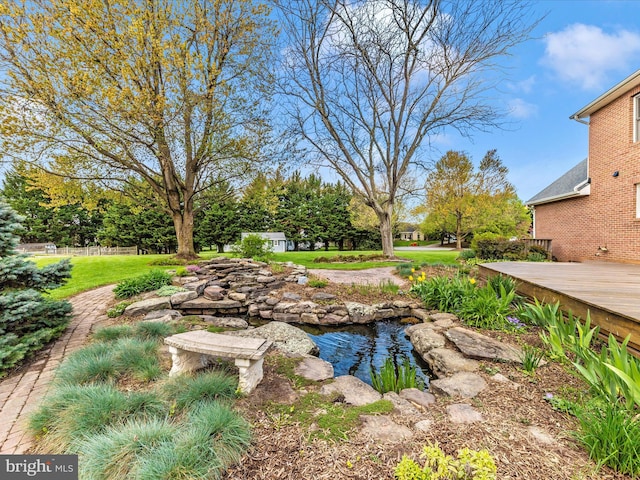 view of yard with a small pond and a deck