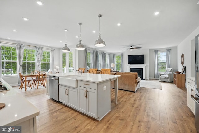 187 Boxelder Dr, Stafford, VA 22554 - kitchen with light countertops, dishwasher, a ceiling fan, a sink, and light wood-type flooring