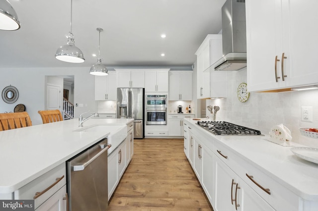 187 Boxelder Dr, Stafford, VA 22554 - kitchen featuring stainless steel appliances, backsplash, light countertops, a sink, and wall chimney exhaust hood