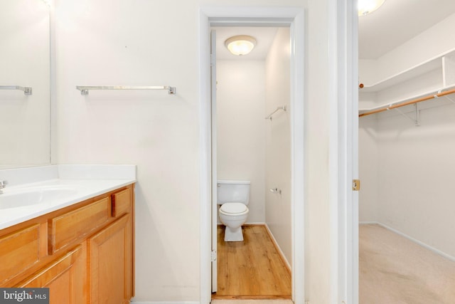 8131 Needwood Rd Unit 102, Derwood, MD 20855 - bathroom featuring vanity, toilet, a spacious closet, and baseboards