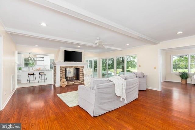3188 Windrows Way, Eden, MD 21822 - living area with wood finished floors, a multi sided fireplace, a ceiling fan, ornamental molding, and baseboards