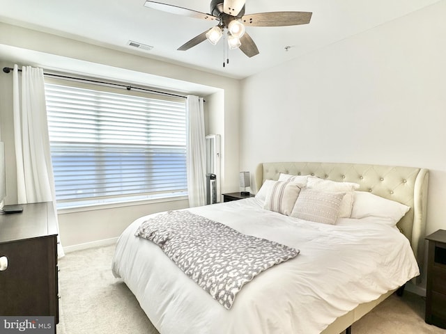 carpeted bedroom featuring visible vents, baseboards, and ceiling fan