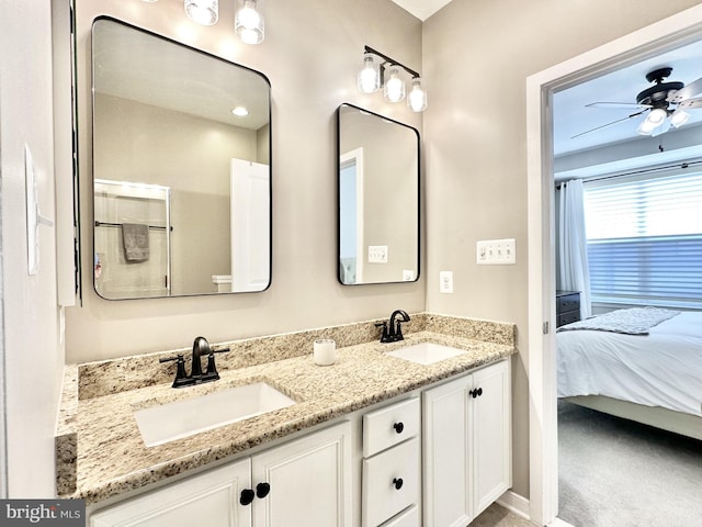 bathroom featuring double vanity, connected bathroom, a ceiling fan, and a sink