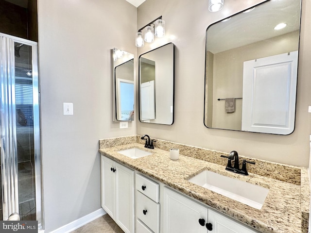 full bathroom with a sink, double vanity, and baseboards