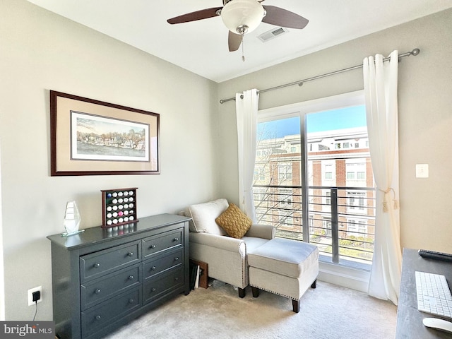 sitting room featuring a wealth of natural light, light carpet, visible vents, and ceiling fan