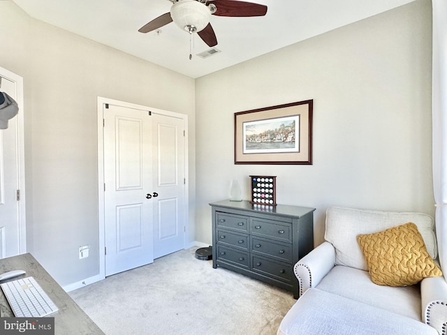 living area with light carpet, baseboards, visible vents, and ceiling fan