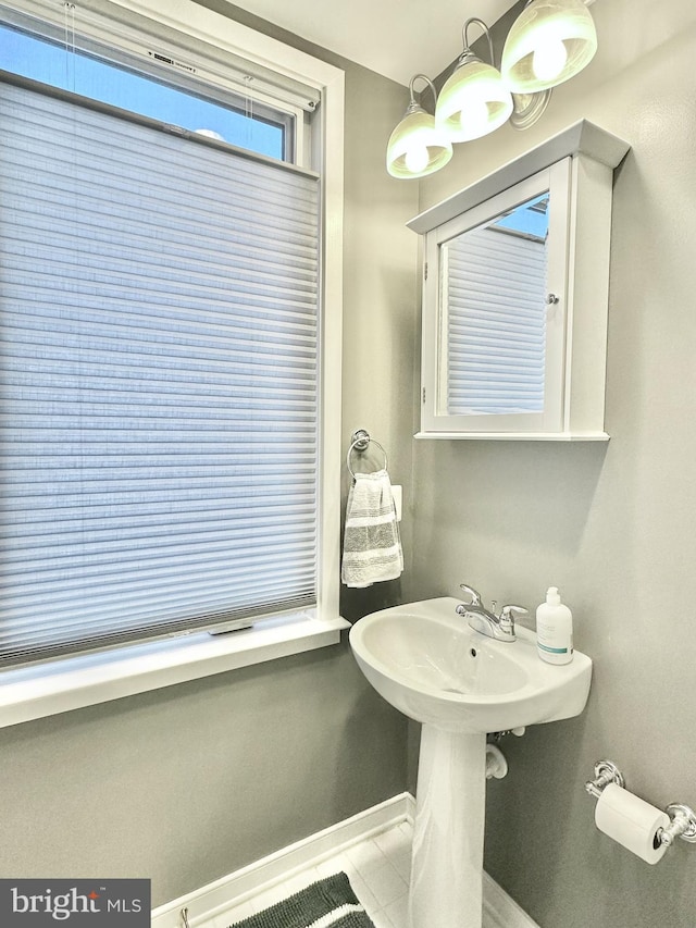 bathroom with baseboards and tile patterned flooring