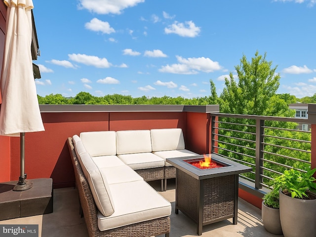 balcony featuring an outdoor living space with a fire pit