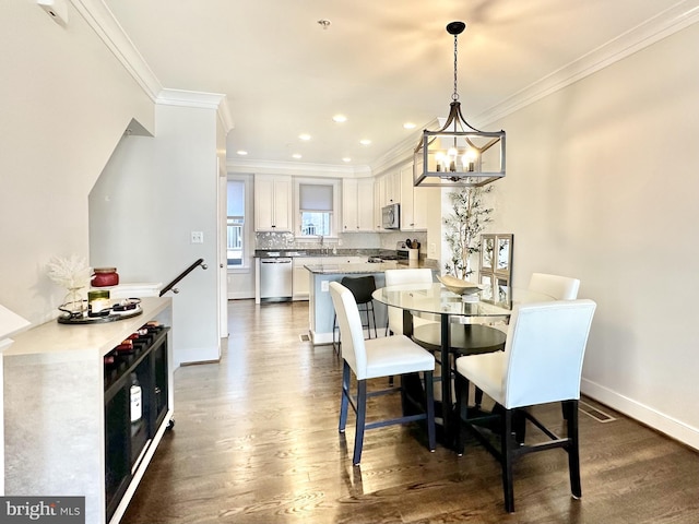 dining area featuring ornamental molding, baseboards, recessed lighting, dark wood finished floors, and a notable chandelier