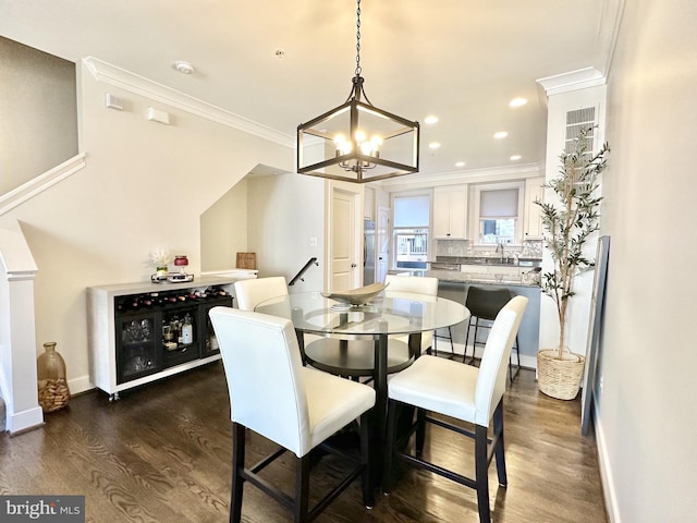 dining room with ornamental molding, recessed lighting, an inviting chandelier, dark wood-style floors, and baseboards