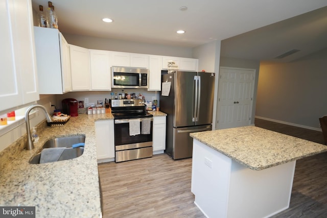 kitchen featuring recessed lighting, a sink, light wood-style floors, white cabinets, and appliances with stainless steel finishes