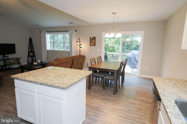 kitchen with an inviting chandelier, white cabinets, and light wood-style floors