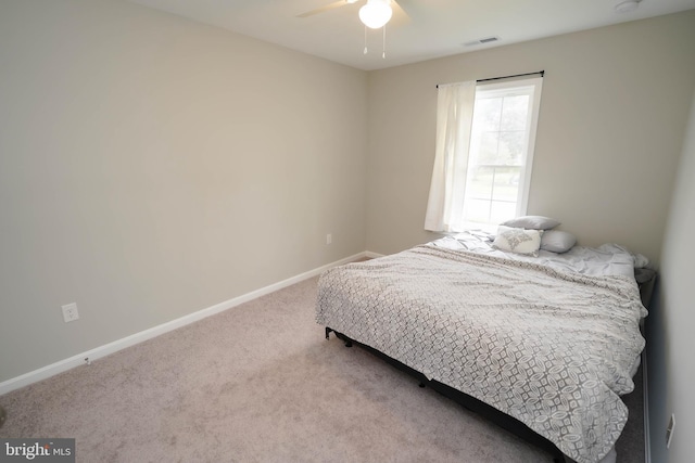 carpeted bedroom featuring baseboards, visible vents, and ceiling fan