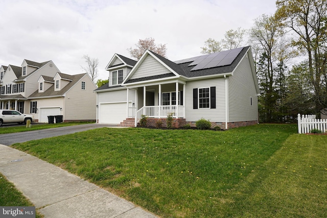 view of front of property featuring a front lawn, roof mounted solar panels, covered porch, and aphalt driveway